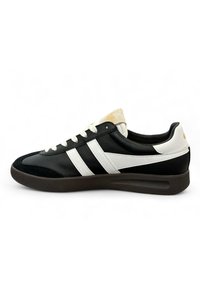 Black leather sneaker with white stripes, textured black toe cap, and cream suede tongue. Features black laces and a brown rubber sole.