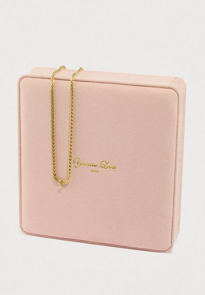 Κολιέ με χρυσή αλυσίδα σε ροζ, υφασμένο κουτί κοσμημάτων με χρυσό λογότυπο. Το κουτί έχει απαλό, σουέτ υλικό και τετράγωνο σχήμα.
