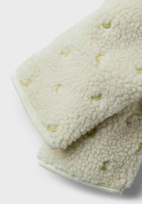 Fleece-foderad sjal i off-white med mjuk textur, prydd med broderade gula halvmånar och ljust färgad kant längs kanterna.