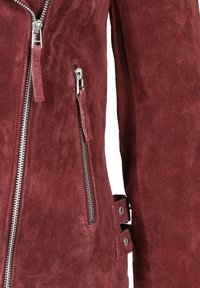 Maroon suède jack met zilveren ritsen, ritslussen, en verstelbare zijbanden met metalen oogjes.