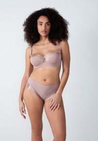 Reggiseno e culotte a vita alta in morbido tessuto nudo. Il reggiseno presenta una leggera imbottitura, ferretto e spalline regolabili; la culotte ha una finitura liscia.