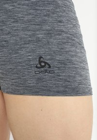 Grijze sportshorts van gestructureerde stof, met een zwart Odlo-logo aan de linkerkant. Close-up van de tailleband en zoom.