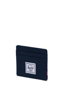 Compact navy cardholder made of fabric, featuring multiple slots and a white Herschel label on the front with red and white striped accent.