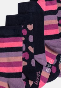 Cinco pares de calcetines con diversos diseños: rayas en rosa y morado, y lunares en rosa y azul marino sobre fondos oscuros.