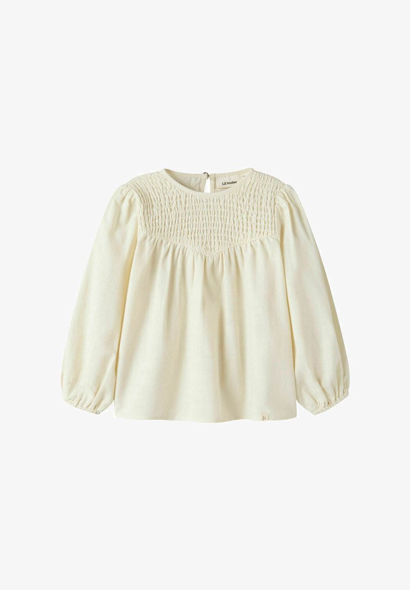 Blouse à manches longues de couleur crème avec détail smocké sur le yoke, encolure ronde, tissu froncé et poignets élastiques.
