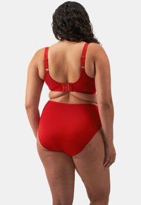 Due pezzi di costume da bagno rosso composto da un reggiseno sagomato con spalline larghe, hardware regolabile e pantaloni high-waisted con una texture liscia.