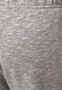 Graue Sweatpants aus weichem, strukturiertem Stoff mit einem dezenten Melange-Muster und einem elastischen Bund für Komfort und Passform.