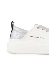 Weiße Sneaker mit einem strukturierten silbernen Absatz, grauen Schnürsenkeln und einer klobigen weißen Sohle. Mit dem Logo "Alexander Smith" in roségoldenem Akzent.