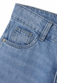 Los pantalones vaqueros de mezclilla azul claro presentan un pequeño bolsillo frontal, costuras cosidas y un lazo para cinturón, con una textura ligeramente desgastada.