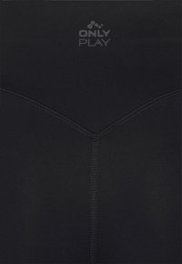 Czarna tkanina z widocznymi pionowymi i ukośnymi liniami stębnowania tworzącymi kształt litery Y pod małym logo z napisem "ONLY PLAY."