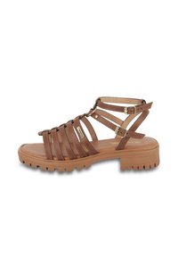 Sandalias marrones con tiras, suela de goma gruesa, diseño de múltiples tiras y hebillas ajustables, con una textura suave y costuras discretas.