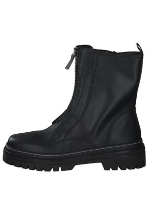 Bottine en cuir noir avec fermeture éclair sur le côté, surface texturée, semelle en caoutchouc épaisse et coutures blanches contrastantes le long du bord de la semelle.