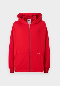 Felpa rossa con zip realizzata in tessuto morbido. Presenta una tasca a marsupio, polsini a costine e un logo Nike bianco sul lato sinistro del petto.