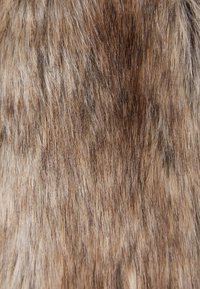 Hnědý umělý kožich s různorodými texturami a odstíny, obsahující jemné, měkké prameny a delší části vlasů, které vytvářejí přirozený vzhled.