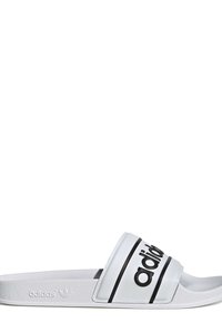 Vit flip-flop sandal med en texturerad rem som har svart "adidas"-logotyp och linjer. Platt sula med slät yta och minimalistisk design.