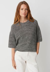 Grauer Strickpullover mit kurzen Ärmeln und Rundhalsauschnitt. Die Textur hat ein dezentes Rippenmuster und eine lockere Passform.