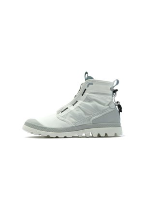 Bottines légères grises en matériau synthétique avec un bout texturé, une fermeture éclair élastique et une semelle en caoutchouc dotée de motifs de crampons distincts.