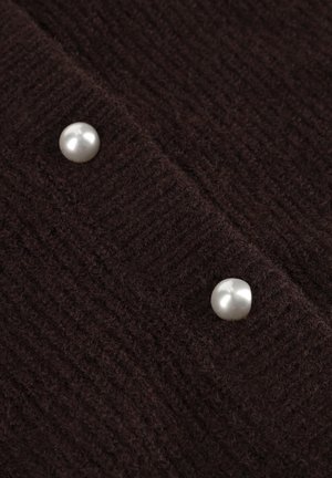 Dunkelbrauner gestrickter Stoff mit einem strukturierten Muster, versehen mit zwei großen perlenartigen Knöpfen entlang der Kante.