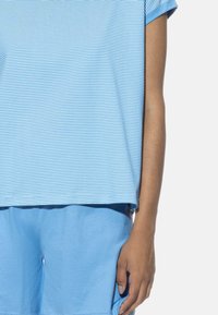 Blauw gestreepte shirt met korte mouwen en een relaxte pasvorm. Gecombineerd met blauwe shorts, die een zachte stof en een casual ontwerp laten zien.