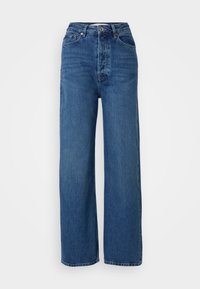 Kõrge vöökoht, sinised denim püksid sirge säärega, viie tasku ja nööpkinni. Sile tekstuur ja klassikaline pestud efekt.