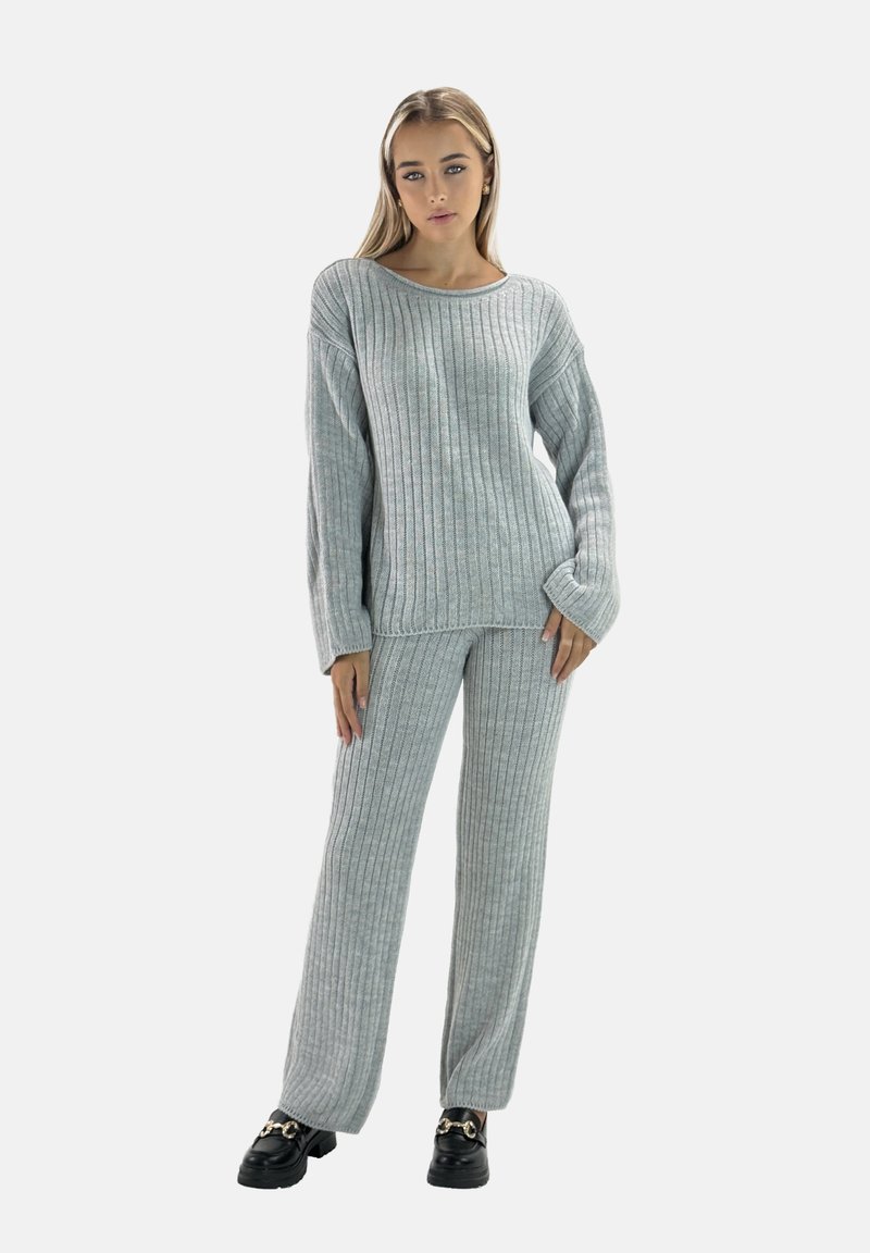 Grauer gerippter Strickpullover und passende Hose, mit entspanntem Schnitt, langen Ärmeln und strukturiertem Stoff, getragen mit schwarzen Schuhen.