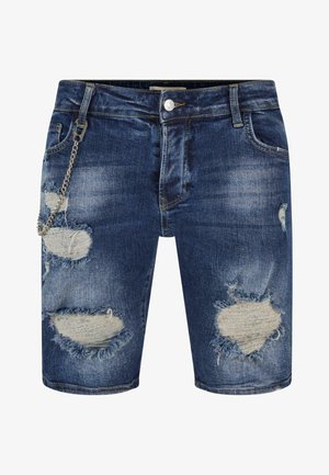 Shorts din denim de culoare bleu închis, cu rupturi uzate și margini descusute, având un lanț argintiu atașat de bucla pentru curea.