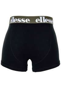 Boxer in cotone nero con elastico verde in vita che presenta il nome del marchio "ellesse" in lettere bianche. Texture liscia, design aderente.
