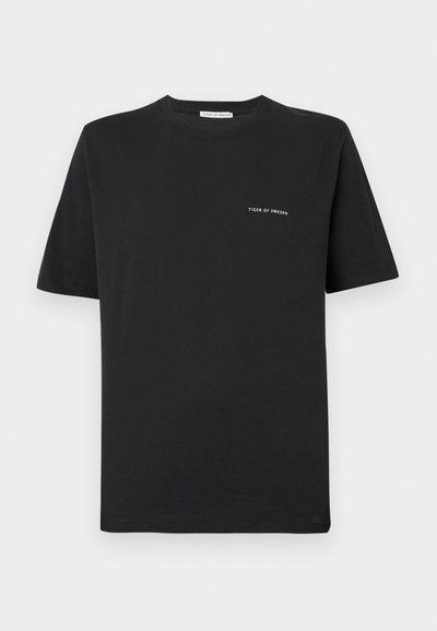 Melna kokvilnas T-kreklu ar apaļu kakla izgriezumu, īsām piedurknēm un mazu balto "TIGER OF SWEDEN" logotipu uz krūtīm. Klasiskā piegriezuma.