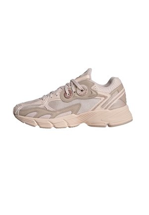 Baskets Adidas beige avec superpositions en mesh et synthétique, fermeture à lacets, et semelle épaisse texturée, présentées de profil sur fond blanc.