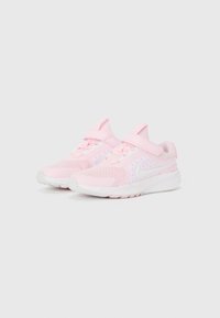 Baskets de sport rose clair avec un dessus en mesh, un design courbé, des accents blancs et une fermeture à sangle ajustable, avec une semelle blanche texturée.