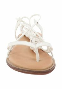 Witte platte sandalen met een minimalistisch ontwerp, voorzien van gekruiste bandjes en een gladde beige voetbed. Flexibele zool met een lichte bruine rand.