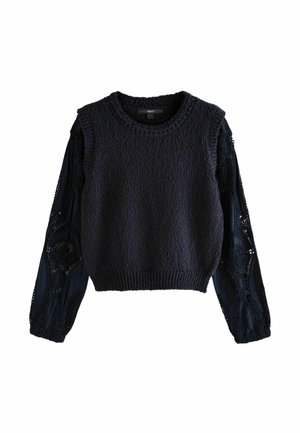 Pull en bleu marine foncé avec un corps texturé et de longues manches en dentelle présentant des motifs complexes. Encolure ronde et design court.