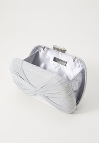 Clutch metallica argento con tessuto testurizzato e design plissettato, dotata di una chiusura arricchita da cristalli e interno in raso.