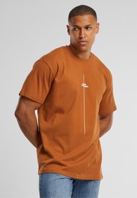 Bruine katoenen T-shirt met korte mouwen, voorzien van een gecentreerde witte grafische tekst "Think Different." Klassieke ronde hals, ontspannen pasvorm.