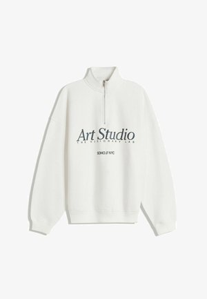 Bela zip-up dukserica z visokim ovratnikom, s grafičkim tiskom koji glasi "Art Studio" i "SOHO // NYC" u tamnoplavoj boji.