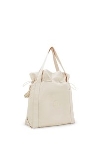 Beige nylon toteväska med dragsnörstängning, två stadiga handtag och en rund logodetail på framsidan. Slät textur, avslappnad design.