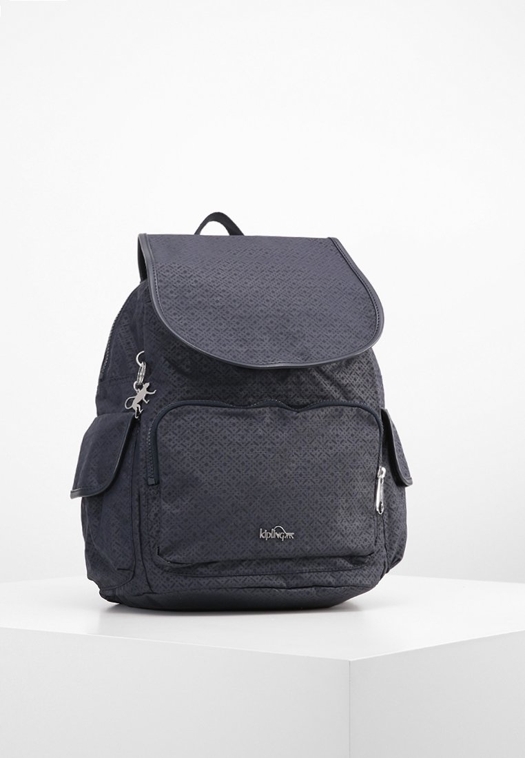 Granatowy plecak z tkaniny z teksturowanym wzorem, z klapą, przednią kieszenią na zamek oraz zewnętrzną kieszenią boczną. Zawiera akcent z logo.