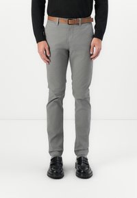 Grijze katoenen broek met een slim fit, met een gladde textuur, voorzakken en een bruine riem. Gecombineerd met zwarte schoenen.