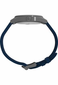 Metallklocka med silverkapsel, klart glasfront och en strukturerad vävd strap i marinblått. Har en lås i rostfritt stål och logotyp på sidan.