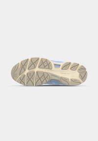 Blå løbesko sål med en tekstureret gummisål, der har trækkraftmønstre og en beige mellemsål, letvægts- og fleksibelt design.