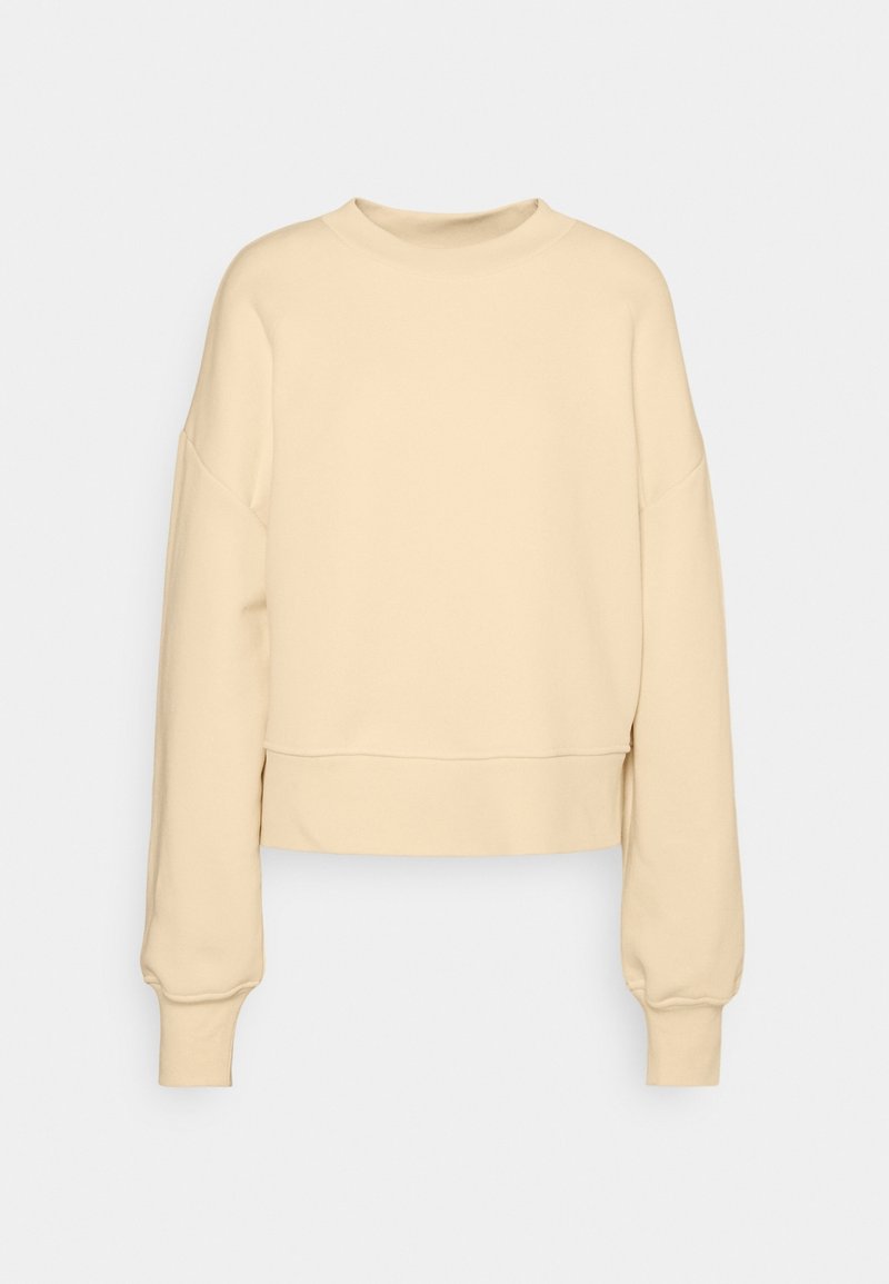 Sudadera recortada beige con mangas largas y ligeramente abullonadas, cuello redondo y puños de canalé. Fabricada en un tejido suave y texturizado.