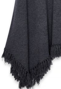 Tumehall soe kangas, mille alumisel serval on pikad fringed, ripub pehmete kortsudega.