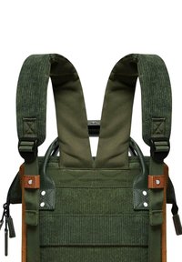 Le sac à dos en tissu vert présente des bretelles larges et ajustables avec une texture côtelée, des coutures renforcées et des accents en cuir marron.