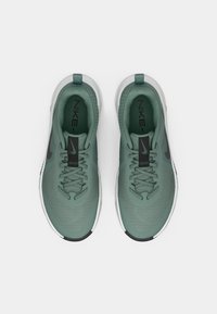 Nike spordijalatsid pehmes roheline värvuses, koos võrgust pealmise osaga, mustade aktsentidega ja valge tallaga. Omab paelasid ja logo keelal.