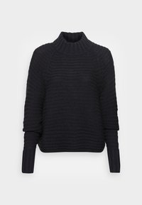 Syntaxen är en mörkblå stickad tröja med hög, ribbad krage, lös passform och texturerade ränder. Långa, vida ärmar och ribbade manschetter.