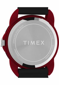 Zegarek Timex z tylną częścią ze stali nierdzewnej, czerwoną plastikową obudową, czarnym paskiem i widocznymi detalami logo. Wodoodporny do 30 metrów.