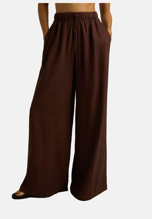 Brązowe szerokie spodnie na elastycznej talii, z detalem w postaci sznurka oraz bocznymi kieszeniami; wykonane z lekkiego, teksturowanego materiału.