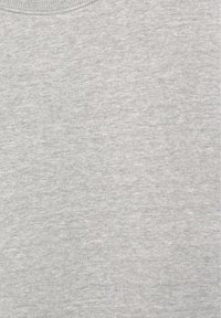 Nærbillede af et lysegråt stof, der viser dets bløde, strikkede tekstur og diskrete melerede mønster.