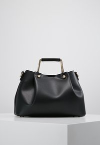 Sort læder håndtaske med en tekstureret overflade, guldfarvede hardware-detaljer, et kort håndtag og en afslappet, struktureret form.