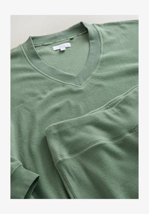 Žalios vilnos dviejų dalių poilsio drabužių komplektas su V formos iškirpte ir elastinga juosmens juosta. Pasižymi minkšta tekstūra ir raukšlėtomis rankogaliais. Paprastas dizainas.